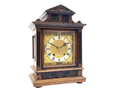 Late 19th century walnut cased mantel clock, sloped arch and cavetto top pediment carved with flower heads, the brass dial wi