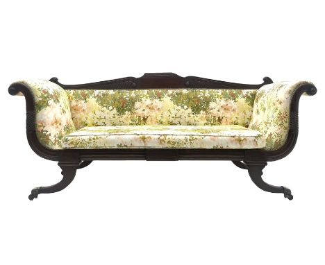 Regency period mahogany settee, scroll and lobe carved cresting rail, upholstered in floral patterned fabric with squab cushi