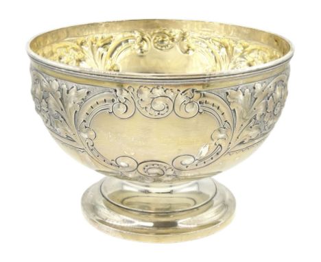 Edwardian silver footed bowl, embossed with foliate scrolls and flower heads between two vacant cartouches, upon stepped circ