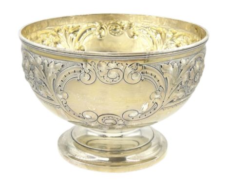 Edwardian silver footed bowl, embossed with foliate scrolls and flower heads between two vacant cartouches, upon stepped circ