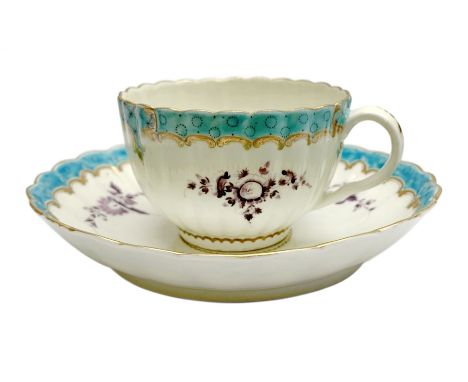 18th century Worcester teacup and saucer, circa 1775-1780, of fluted form hand painted with floral sprays in puce and further