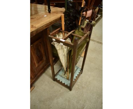 An early 20th Century oak stick stand, including lacework parasol, cane handled umbrella, walking cane and vintage feather du