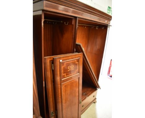 An Edwardian mahogany and inlaid mirror door triple wardrobe