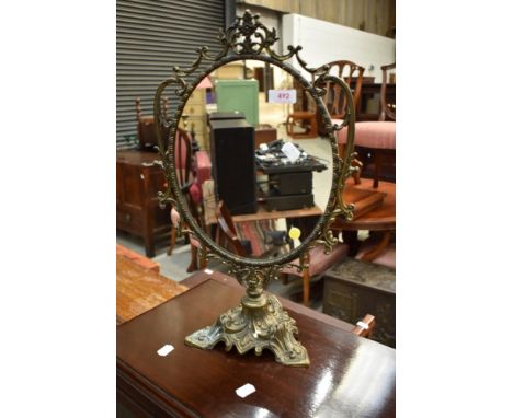 An early 20th Century ornate brass toilet mirror