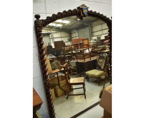 A 19th Century oak over mantel or grand hall mirror, having twist column and carved support , central cartouche to arch, with