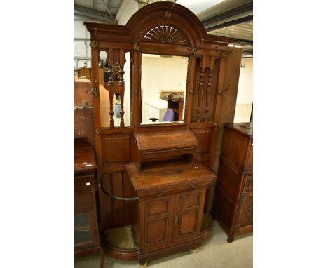 An impressive Victorian oak hall stand having fan design over mirror, and glove box with lift lid under, frieze drawer stampe