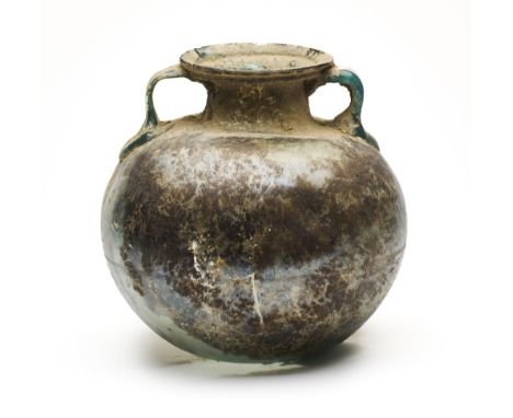 A ROMAN BLUE GLASS SPHERICAL BODIED CINERARY URN, CIRCA 2ND-3RD CENTURY A.D.  with two applied strap handles, everted rim whe