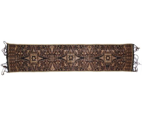 A TENGANAN COTTON IKAT SCARF, INDONESIA, 19TH CENTURY of long rectangular form, with tasselled ends, decorated in red and res