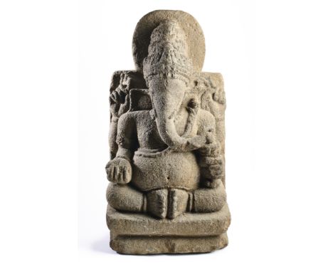 A JAVANESE ANDESITE FIGURE OF GANESHA, INDONESIA, 10TH-11TH CENTURY  the four-armed, elephant-headed pot-bellied deity seated