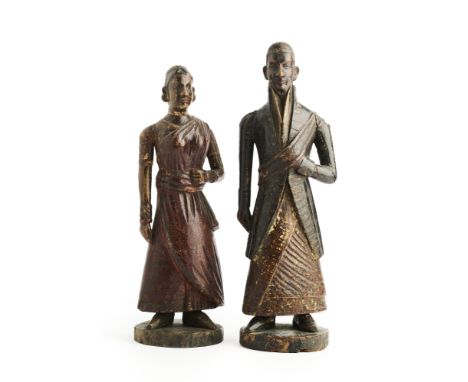 A JAVANESE COUPLE, INDONESIA, 19TH CENTURY  carved and painted wood with gilt, the man wearing a coat with high collar and sa