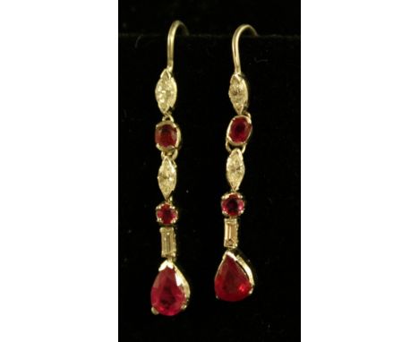 A pair of ruby and diamond drop earrings, each inset with two navette and a baguette cut diamond and three oval round and pea