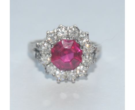 A synthetic vibrant red ruby and mossanite/diamond cluster ring, central vibrant red octagonal cut stone surrounded by a band