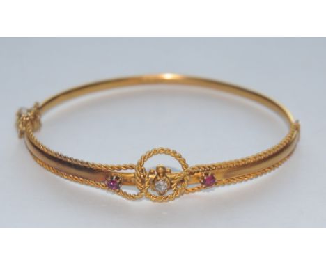 An Edwardian style white sapphire and red spinel hinge bangle, interlaced rope twist and flat bar body, stamped 15ct, 60mm wi