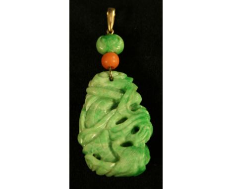 A carved green jade tablet pendant, as a dragon and fish entwined, coral bead and diamond accented bar and suspension loop, 7