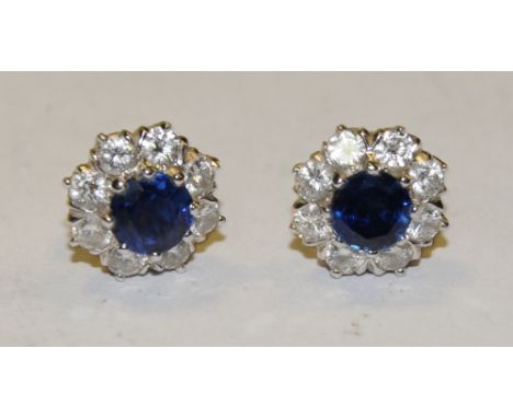 A pair of sapphire and diamond cluster earrings, each with a central vibrant light blue round cut sapphire approx 0.60ct, sur