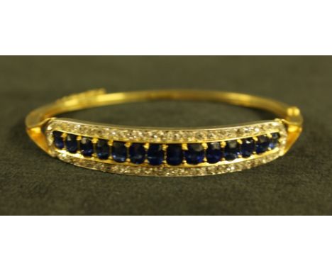 A sapphire and diamond hinge bangle, central row of fourteen mixed cushion cut blue sapphires surrounded by a row of fifty si