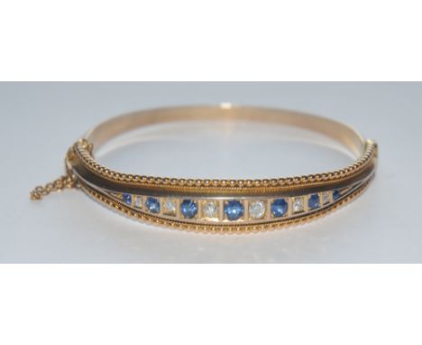 A sapphire and diamond hinge bangle, alternately inset with seven blue sapphires and six round brilliant cut graduating stone