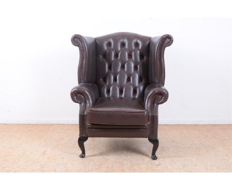 Winchester fauteuil bekleed met bruin leder afgezet met koperen siernagels, met etiket onder kussen.