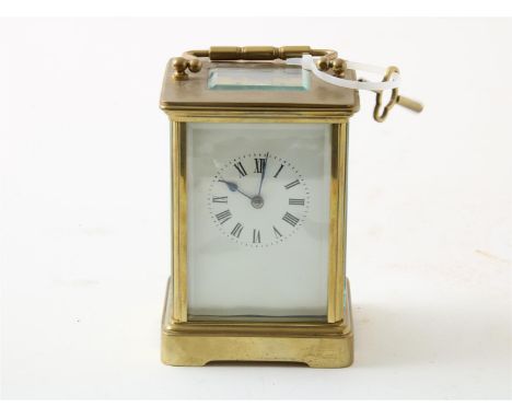 Carriage clock in koperen behuizing, hoogte 13 cm. Met sleutel.