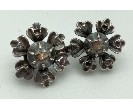 A vintage double flower design white gold brooch set with diamond chips. Tests as 14ct. Each flower set with a rough cut diam
