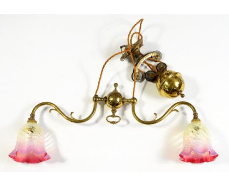 A VICTORIAN BRASS RISE AND FALL LIGHT FITTING, WITH TWIN CRANBERRY SHADES, 68CM W