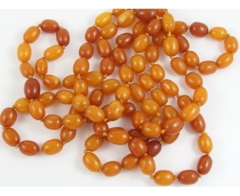 An opera length of amber coloured beads of opaque orange colour, with swirls of clear and lighter colours throughout, weight 