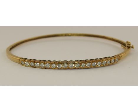 A 9ct diamond set bangle internal dimensions 64 mm x 55mm, approx diamond combined weight 0.76cts