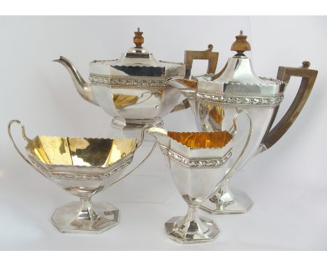 A four piece silver tea service by Elkington & Company, London 1919, the octagonal faceted body with a foliate band and wavy 