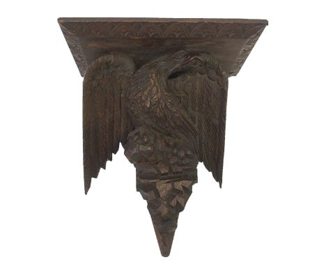 A carved oak wall bracket the rectangular shelf supported by an eagle perched on a rock, 45cm high