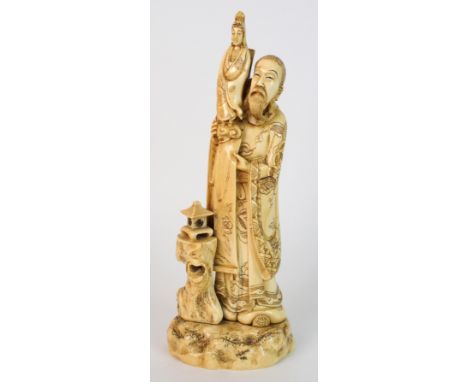 A Japanese ivory okimono of Kannon raised on the shoulder of an immortal figure, his robes decorated with foliage, beside a l