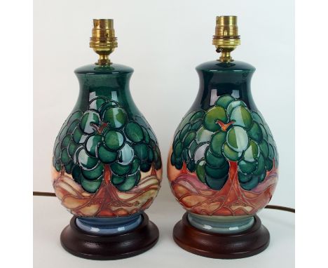Two Moorcroft pottery Mamoura lamps bases designed by Sally Tuffin, the lamps mounted on circular wood bases, decorated with 