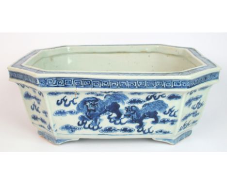A Chinese blue and white octagonal planter painted with Buddhistic lions and cloud scrolls beneath key pattern on bracket fee