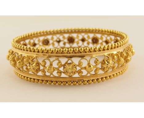 A  filigree bangle stamped 22ct with cut work floral decoration and granulation detail, width across the diameter 62mm, weigh