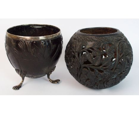 A Georgian white metal mounted carved coconut cup with plain silver metal rim and three silver metal feet with paw terminals,