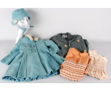 A collection of vintage clothing for girls, including: knitwear, hats, a burnt orange dress with smocking, a 1940s green coat