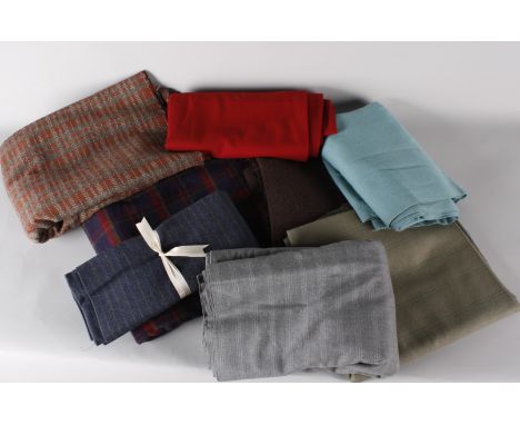 A suitcase of vintage tweed and dressmaking fabrics, including: a bolt of pale grey suiting, a large piece of grey and brown 