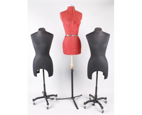 Two black fabric covered costume display mannequins on wheels; together with a red adjustable mannequin on wheels, (3).