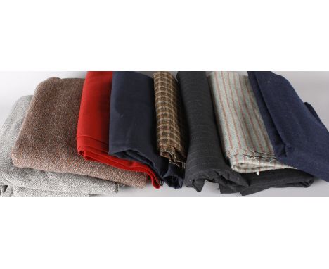 A suitcase of vintage tweed and dressmaking fabrics, including: a bolt of charcoal grey pinstripe suiting, a bolt of green an