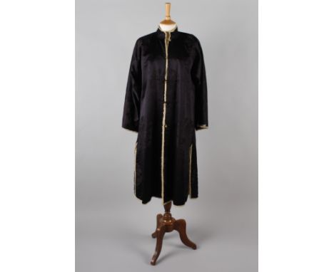 A Chinese midnight blue silk winter coat, lined with sheepskin, having a Mandarin collar, side vents and spherical gilt metal
