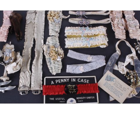 A collection of vintage wedding garters and other wedding related items, including: a blue satin suspender belt decorated wit