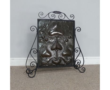 An Art Nouveau copper Firescreen, embossed with stylised hearts and foliage, framed in scrolled wrought iron, H 70 cm. 