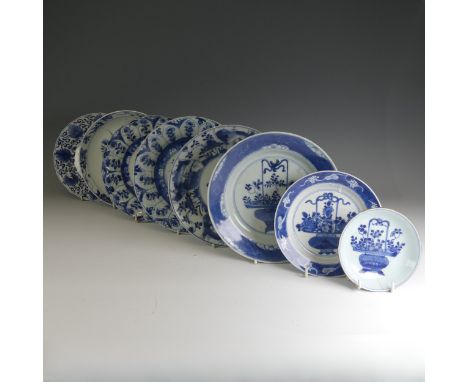 A near pair of early 18thC Chinese porcelain blue and white Plates, the well decorated with flower basket motif and enclosed 