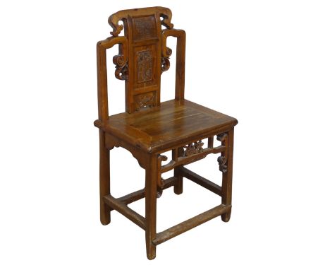 A 20th century carved Chinese hall Chair, scrollwork back with centre panel carved with figure and floral designs, above soli