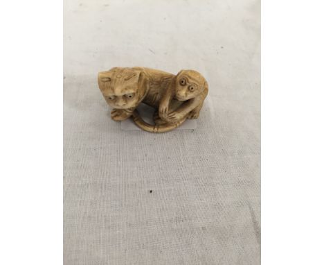 A Meiji period netsuke of tiger and monkey, signature to tail