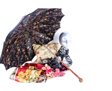 An early 20th Century black silk parasol with a vibrant floral lining; together with silk and velvet millinery flowers,  a bl