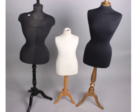 An hour-glass shaped mannequin on a wooden stand, with a modern black fabric cover; with a modern child-sized mannequin, with