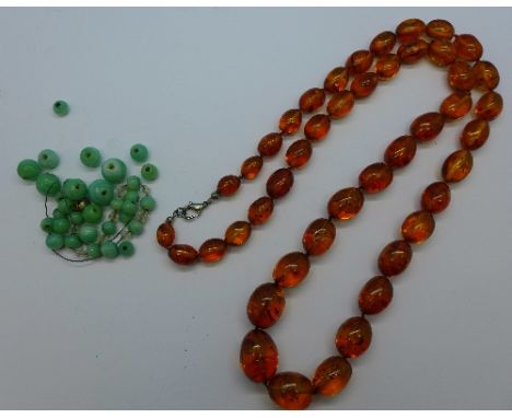 A string of amber beads and a string of green beads, possibly jade, require stringing