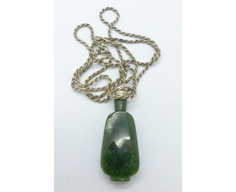 A jade pendant on a silver chain