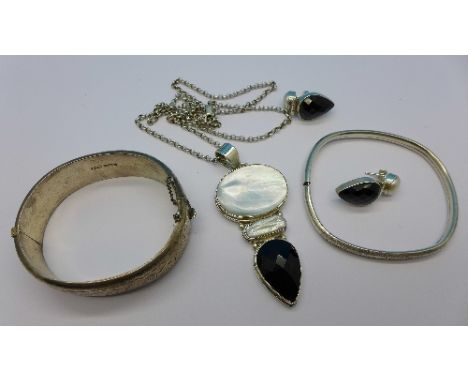 A hallmarked silver bangle, a 925 silver bangle and a silver mounted pendant with matching earrings