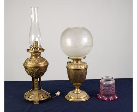 TWO BRASS OIL TABLE LAMPS, one with embossed foot, engraved reservoir and frosted glass shade, 17 ½? (44.4cm) high, the other